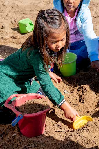 Student digging in the sand